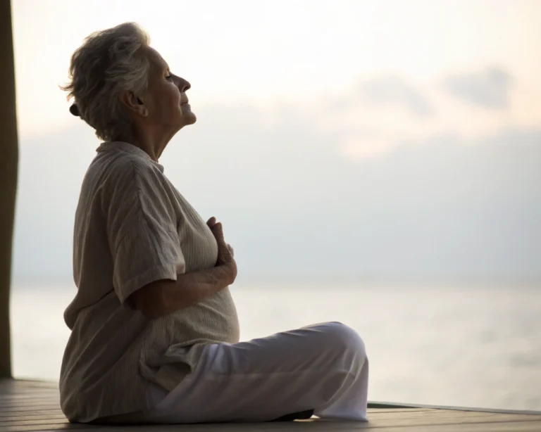 Elderly person practicing breathing exercises in a serene environment with a soft glow, emphasizing mindfulness.