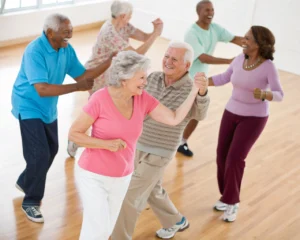 Un grupo de personas mayores disfrutando de una clase de baile en un centro comunitario, mostrando sonrisas y energía en un ambiente vibrante y acogedor.