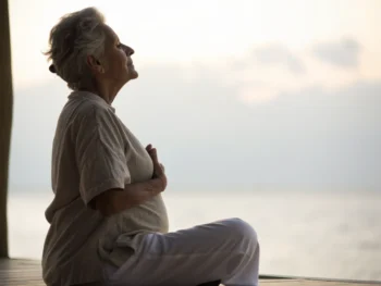 Elderly person practicing breathing exercises in a serene environment with a soft glow, emphasizing mindfulness.